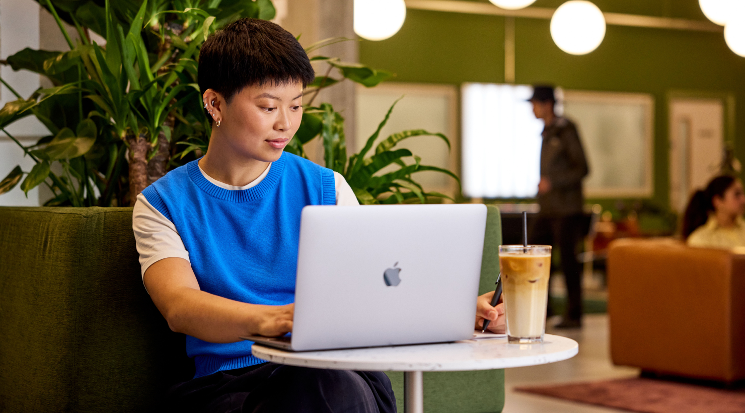 A woman in a blue sweater working at a desk